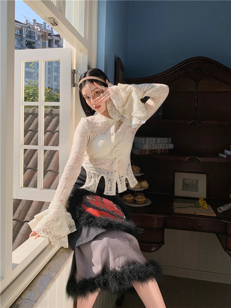 Elegant lace patchwork blouse with ruffled long sleeves and a button-down front in a classic off-white and black color palette.
