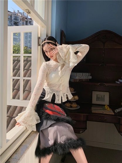 Elegant lace patchwork blouse with ruffled long sleeves and a button-down front in a classic off-white and black color palette.