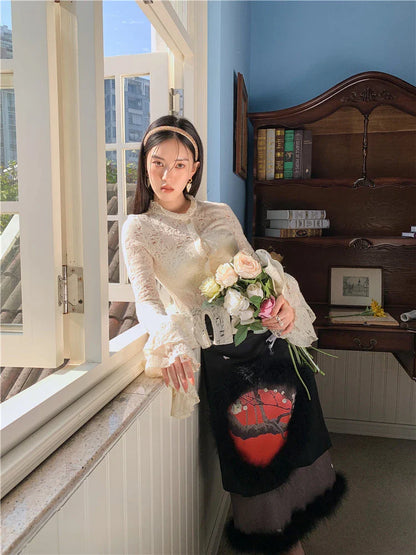 Elegant lace patchwork blouse with ruffled long sleeves and a button-down front in a classic off-white and black color palette.
