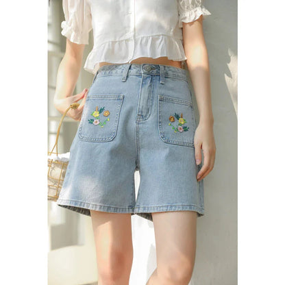 Light blue denim shorts with delicate floral embroidery, providing a stylish and comfortable summer look for women.