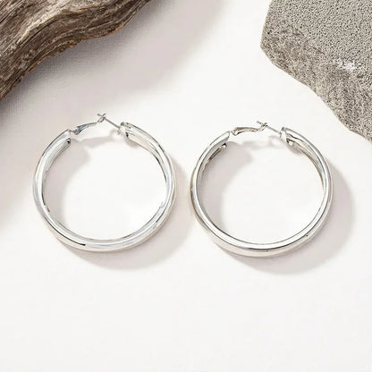 Glossy geometric metal hoop earrings in a silver finish, a trendy and versatile fashion accessory