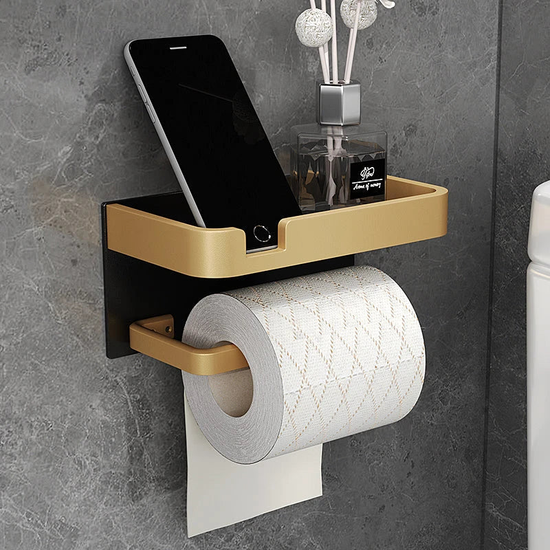 Black and gold aluminum bathroom paper holder with a convenient phone shelf, a stylish and functional accessory for modern bathrooms.