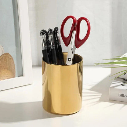 Elegant gold stainless steel desk organizer holding pens, pencils, and makeup brushes on a modern workspace