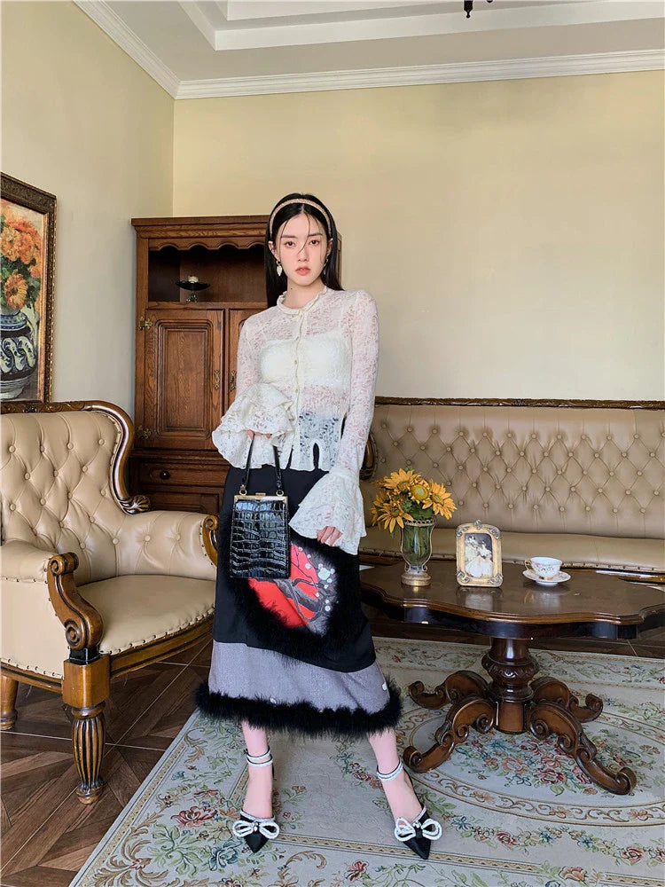 Elegant lace patchwork blouse with ruffled long sleeves and a button-down front in a classic off-white and black color palette.