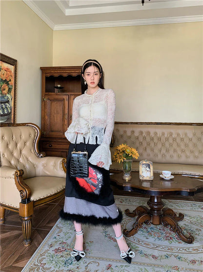 Elegant lace patchwork blouse with ruffled long sleeves and a button-down front in a classic off-white and black color palette.