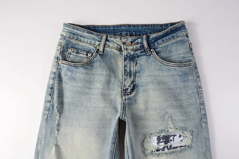 American High Street fashionable men's ripped black and white patch jeans in a light blue denim color