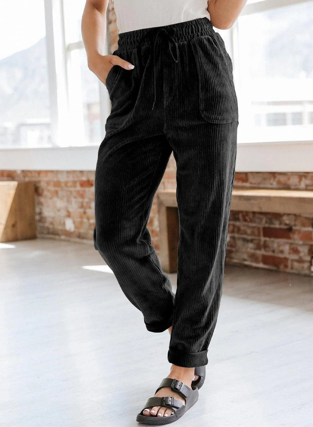 A pair of stylish corduroy pants for women with a wide-leg silhouette, elastic waistband, and side pockets.
