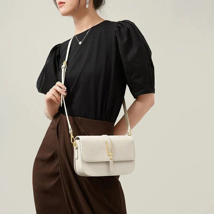 Elegant white leather crossbody bag for women with adjustable strap and multiple interior pockets for organized storage.