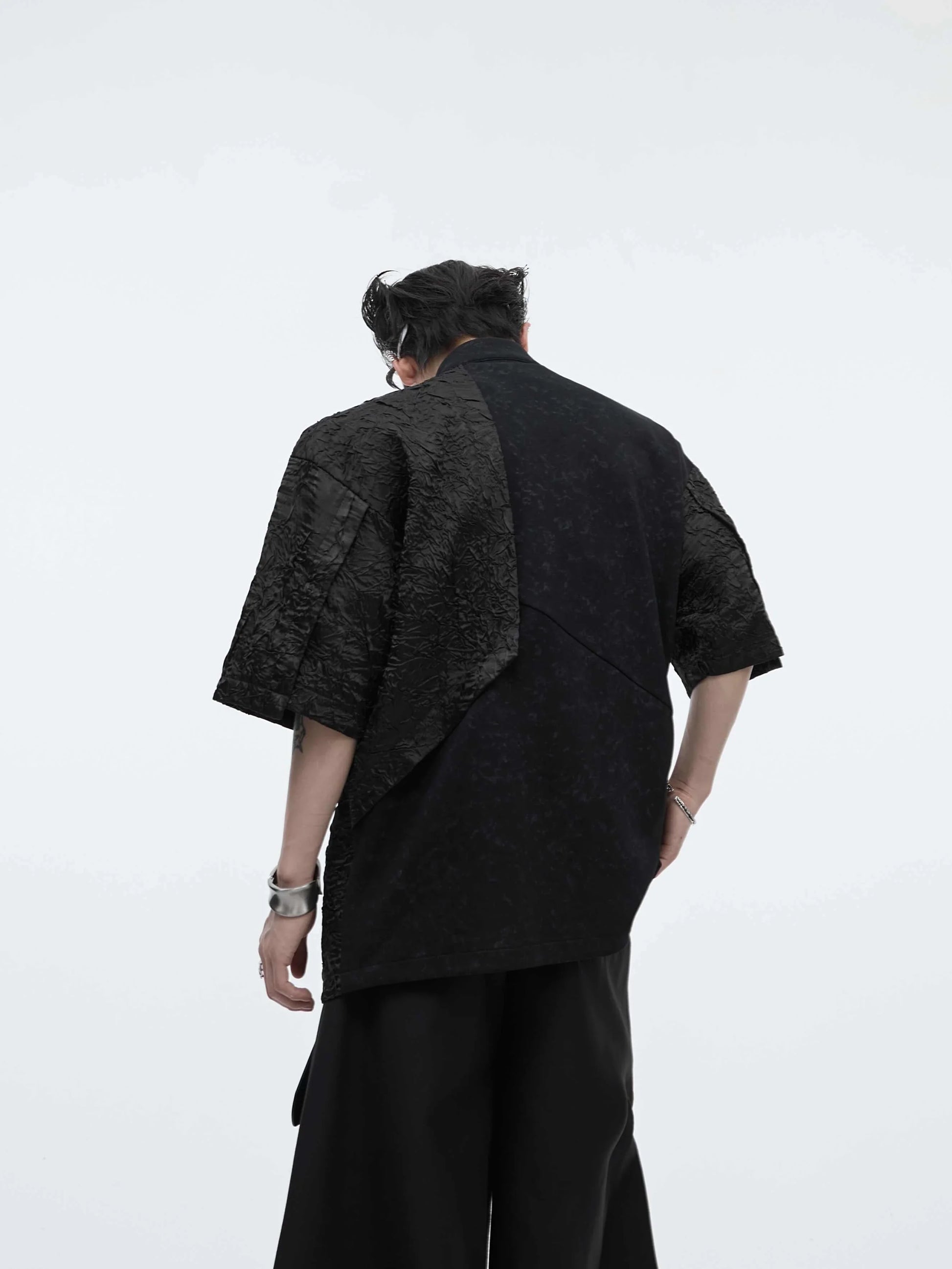 A black and white t-shirt with padded shoulders and a buckle design, offering a relaxed and comfortable fit.