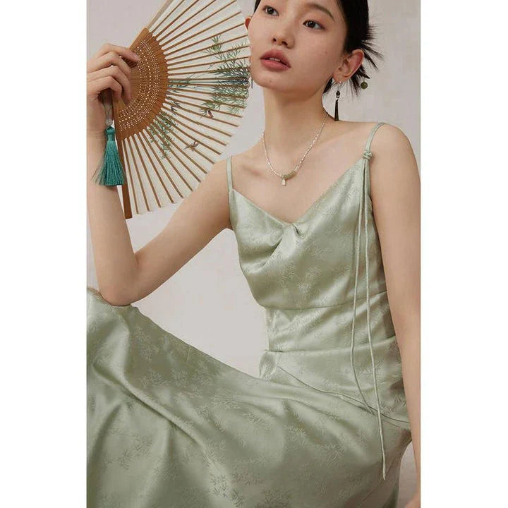 Elegant mint green midi dress with spaghetti straps, featuring a slim fit and intricate embroidery details