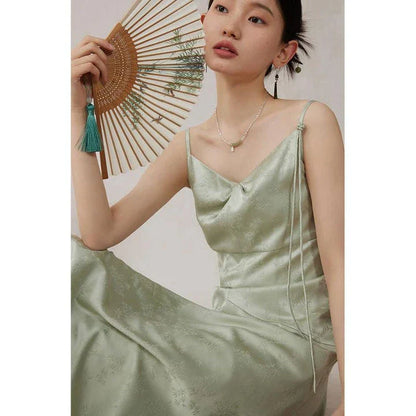 Elegant mint green midi dress with spaghetti straps, featuring a slim fit and intricate embroidery details