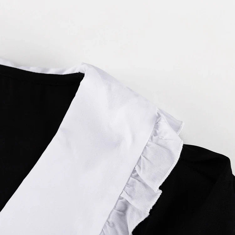 Black and white color-blocked dress with long sleeves and a doll collar, showcasing a timeless and sophisticated style.