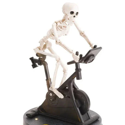 Animated skeleton cycling ornament in white, with the skeleton gracefully pedaling a tiny bicycle