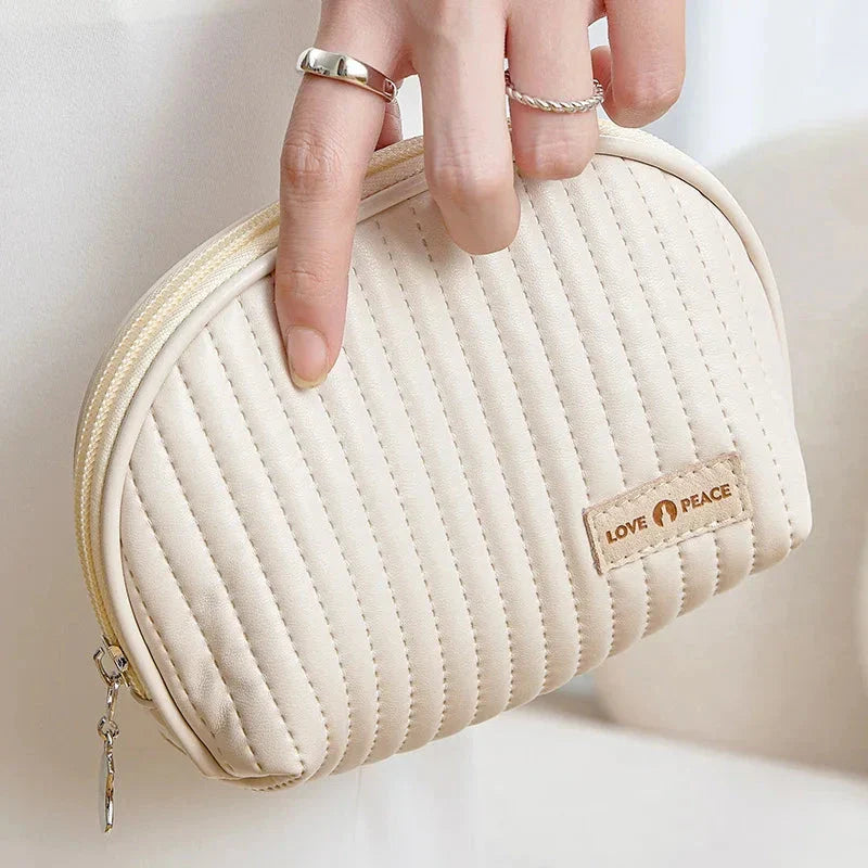 Stylish compact makeup bag made of premium PU leather in light blue color, with a sleek minimalist design for modern women