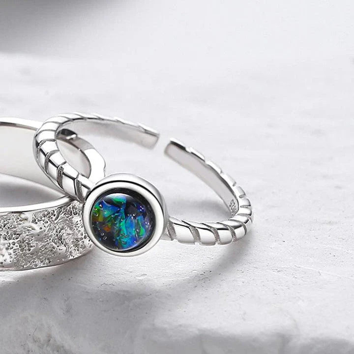 A sterling silver couple's ring set featuring a captivating glass design and an adjustable fit