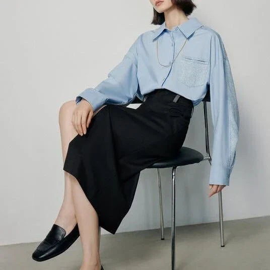 High-waisted slim-fit black midi skirt with metallic decoration, sequin detailing, and split hem