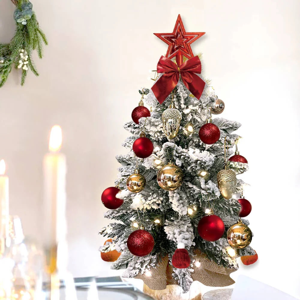 A 2-foot mini Christmas tree with flocked snow-covered branches, string lights, and charming ornaments, creating a cozy winter wonderland on a tabletop.