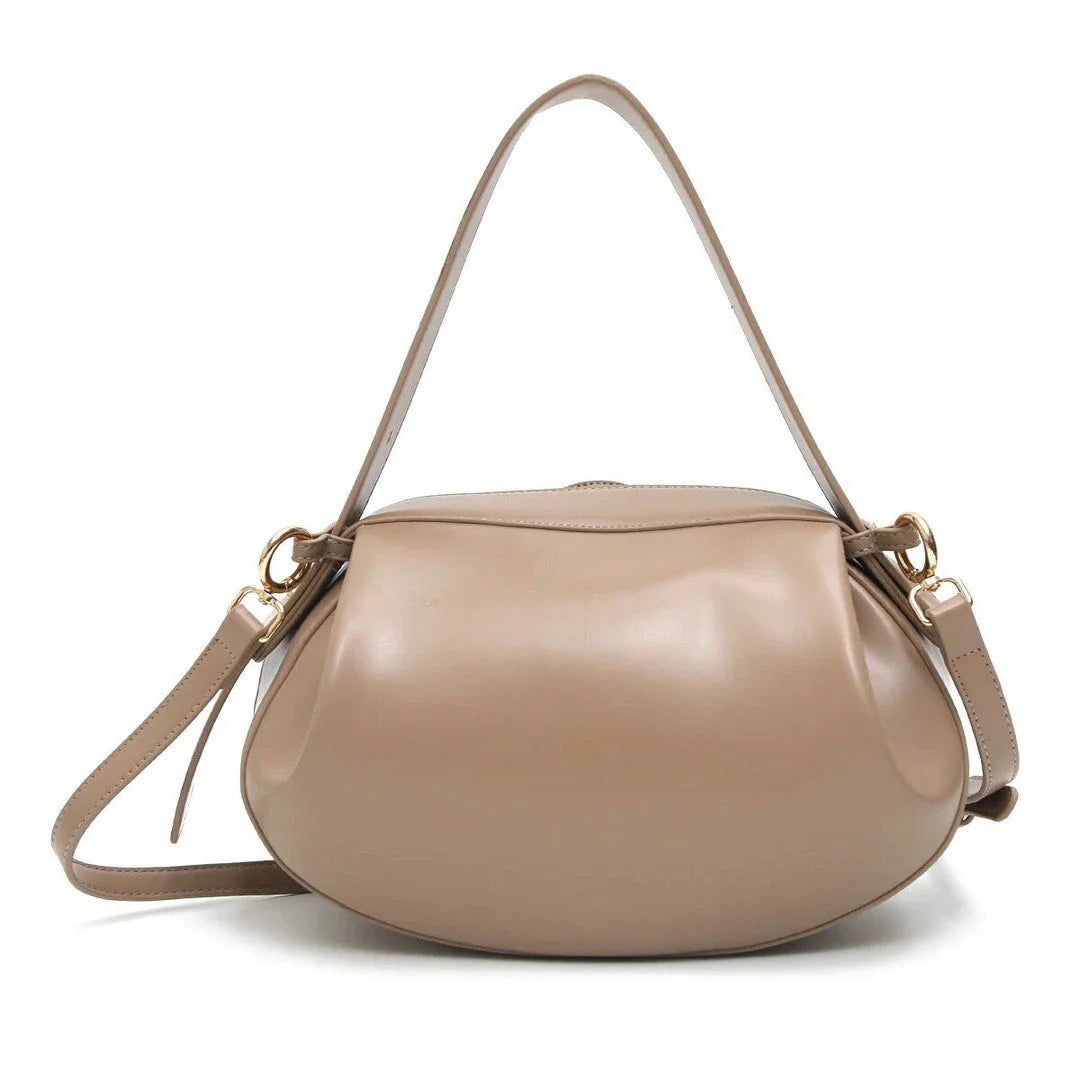 Circular vegan leather handbag in a tan color, with a sturdy build and thoughtful interior design for versatile use.