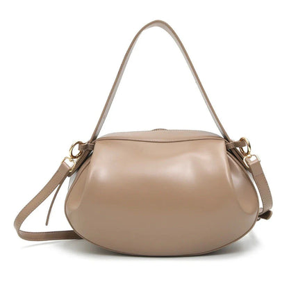 Circular vegan leather handbag in a tan color, with a sturdy build and thoughtful interior design for versatile use.