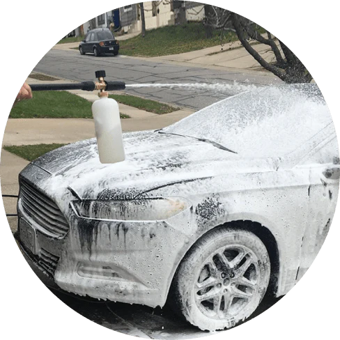 A compact, plastic car wash foam-generating tank with a copper connector to attach to a standard garden hose.