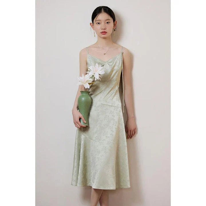 Elegant mint green midi dress with spaghetti straps, featuring a slim fit and intricate embroidery details