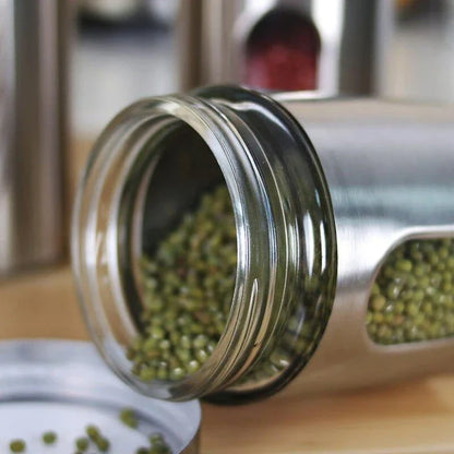 Stainless steel and glass spice jars in various sizes with airtight lids, perfect for organizing and preserving spices in a modern kitchen.
