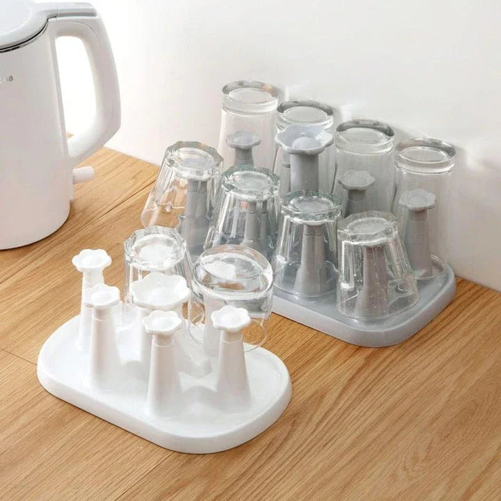 Flower-shaped mug holder rack in white, with 8 slots for organizing and displaying mugs on a kitchen countertop