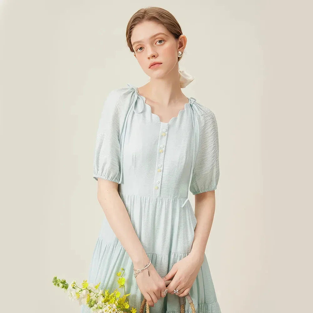 A chic, French-inspired summer dress with an empire waistline, V-neck, and A-line silhouette, perfect for seaside elegance.