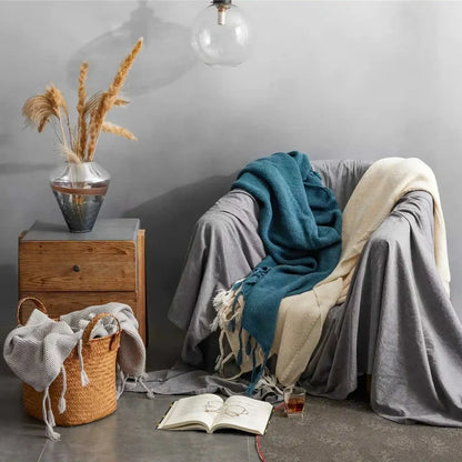 Luxurious Nordic wool knitted throw blanket with tassels in a solid gray color, a cozy and elegant home decor accessory