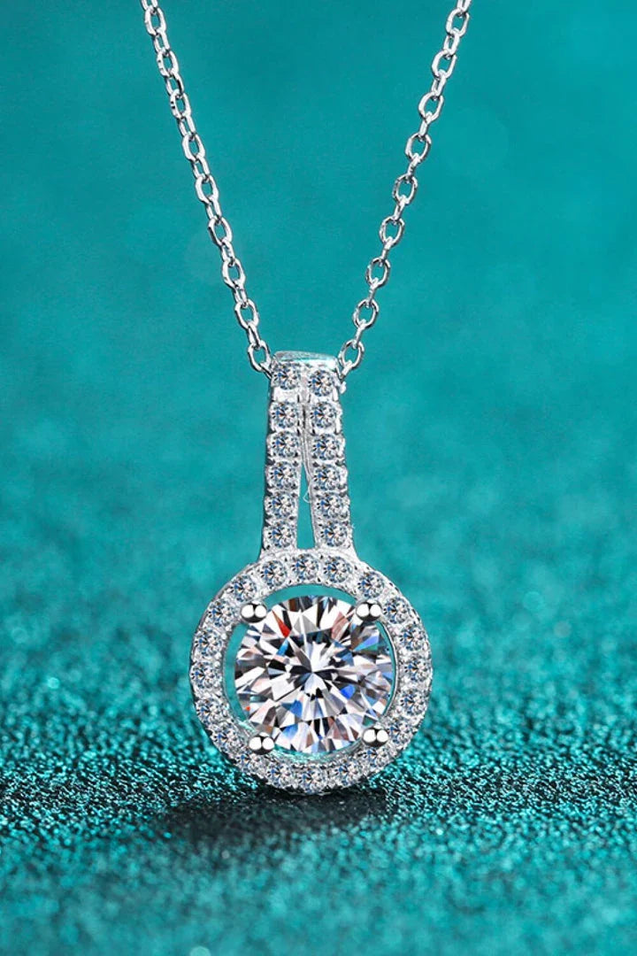 A sterling silver necklace with a round moissanite stone pendant, showcasing a sparkling and elegant design.