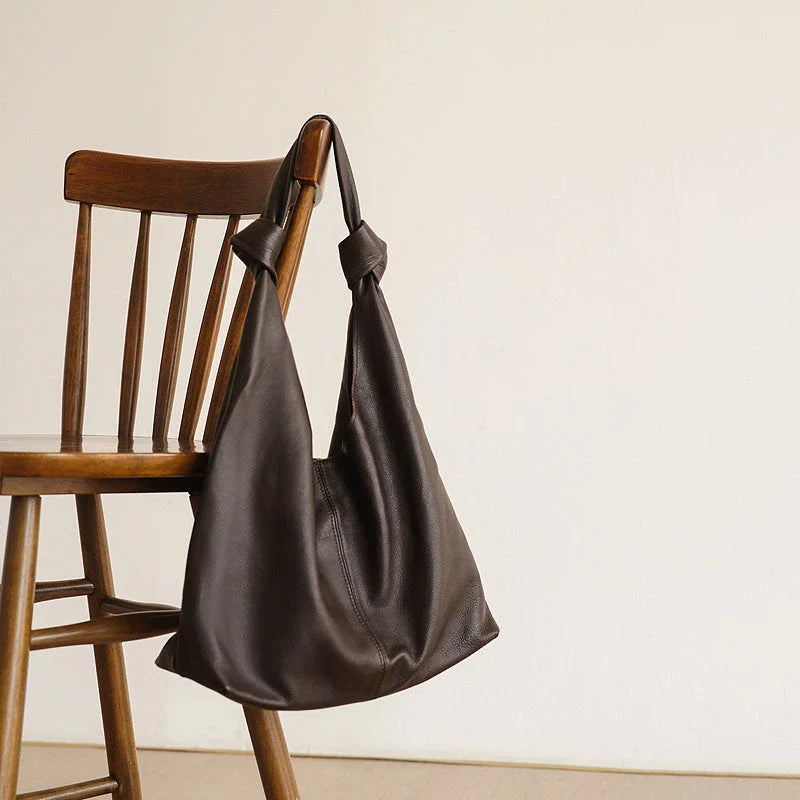 Luxurious oversized genuine leather hobo shoulder bag in black, featuring a spacious interior, multiple compartments, and a soft, flexible design for everyday use.