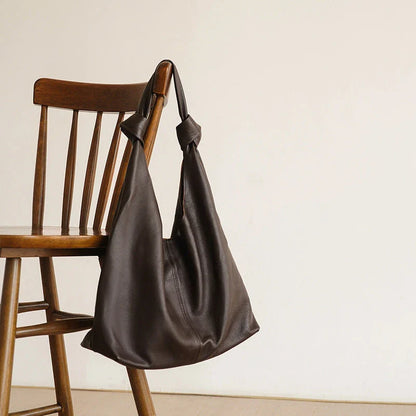 Luxurious oversized genuine leather hobo shoulder bag in black, featuring a spacious interior, multiple compartments, and a soft, flexible design for everyday use.