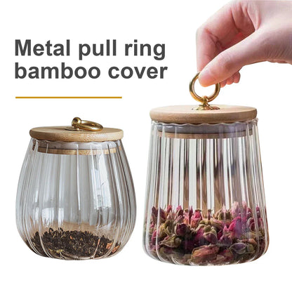 Elegant glass canisters with flower-shaped metal handles and airtight bamboo lids for stylish kitchen storage