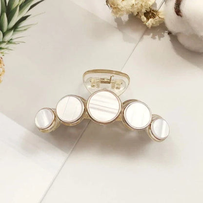 Elegant white marble circle hair claws that add a chic, fashionable touch to any hairstyle
