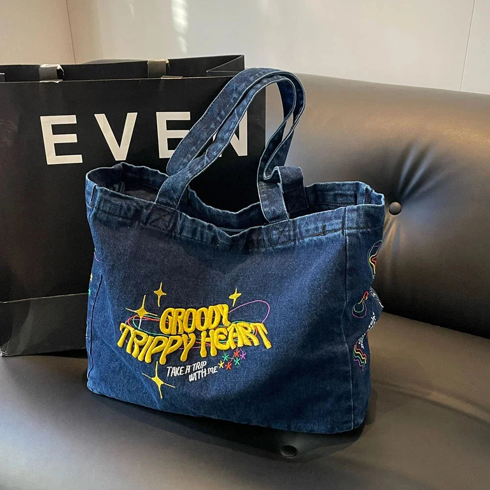 A stylish denim shoulder bag with embroidered details, perfect for everyday use and carrying all your essentials