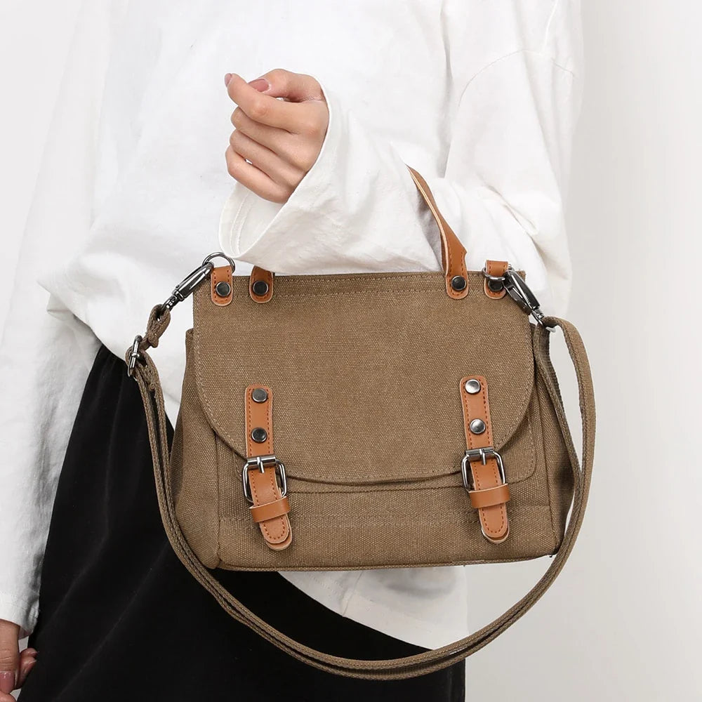 A stylish women's canvas crossbody handbag in an orange color, featuring a small square shape and a horizontal design.