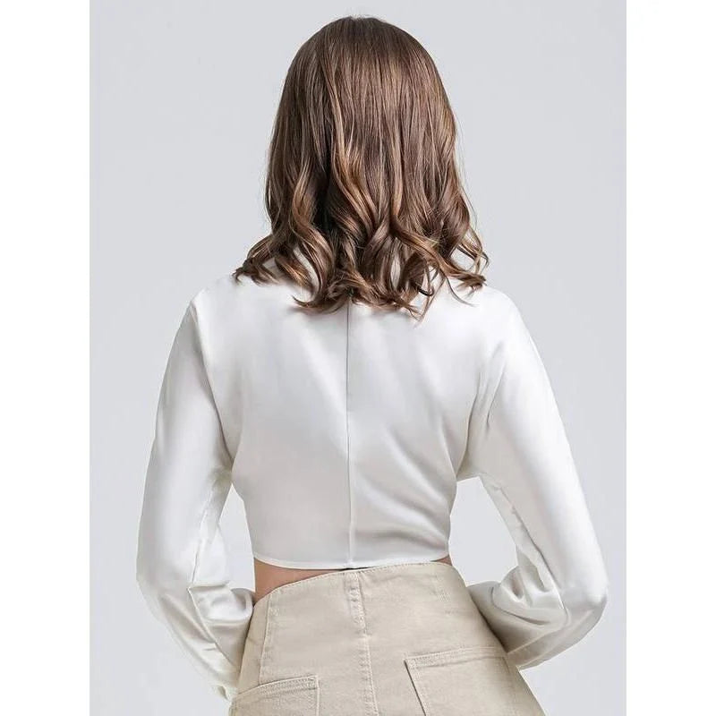 Elegant white vintage-inspired crop blouse with v-neck and long sleeves, a timeless and versatile wardrobe essential