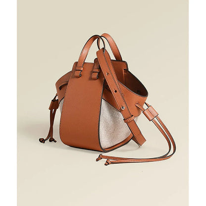 A stylish drawstring bucket bag made from premium cowhide leather and canvas, featuring a spacious main compartment, adjustable shoulder strap, and a softly structured design.