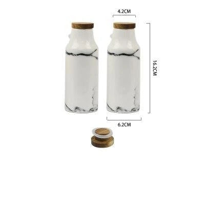 Elegant ceramic salt and pepper oil bottle set with wooden lids, perfect for storing and displaying seasonings and cooking oils in a modern kitchen