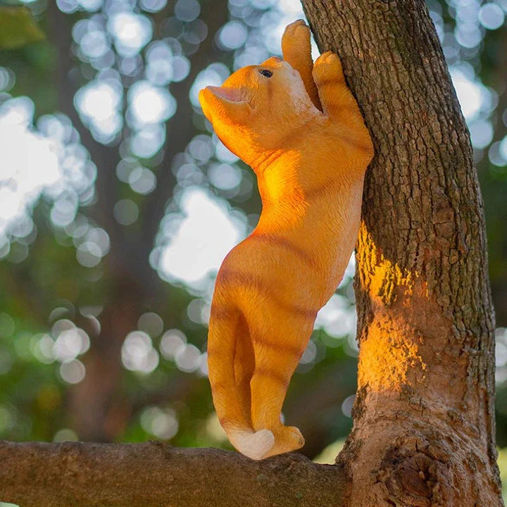 Charming resin cat statue with lifelike details, climbing on a tree branch and adding whimsical flair to any garden or indoor space.