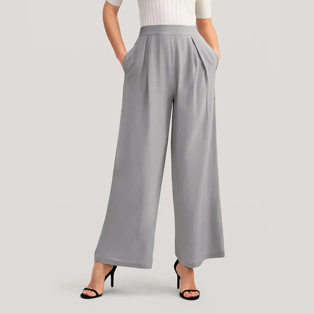 Elegant grey silk wide-leg pants with a high-waist design and concealed side zipper for a flattering, comfortable fit.