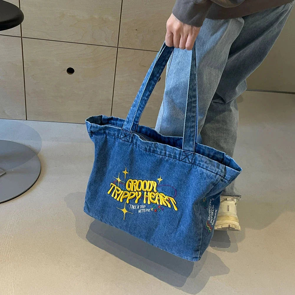 A stylish denim shoulder bag with embroidered details, perfect for everyday use and carrying all your essentials