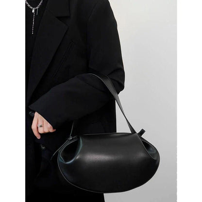 Circular vegan leather handbag in a tan color, with a sturdy build and thoughtful interior design for versatile use.