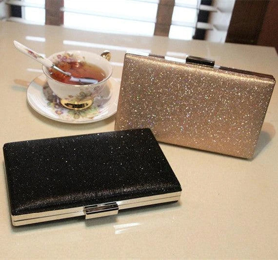 A shiny, metallic dinner clutch bag with a detachable chain strap for versatile carrying options