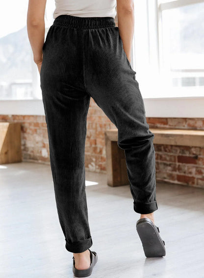 A pair of stylish corduroy pants for women with a wide-leg silhouette, elastic waistband, and side pockets.