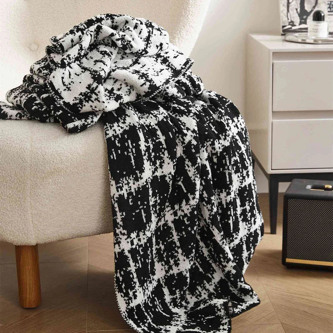 Luxurious white and black plaid wool knit blanket for cozy home, travel, and relaxation
