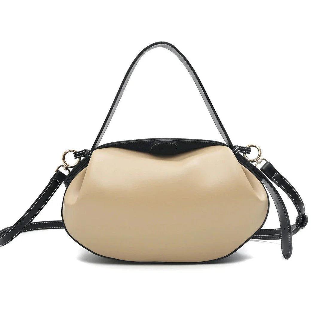 Circular vegan leather handbag in a tan color, with a sturdy build and thoughtful interior design for versatile use.