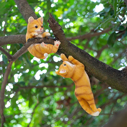 Charming resin cat statue with lifelike details, climbing on a tree branch and adding whimsical flair to any garden or indoor space.