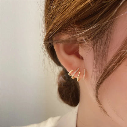 Elegant gold-toned zircon four-claw stud earrings with a classic cuff design, offering a sparkling and sophisticated look.