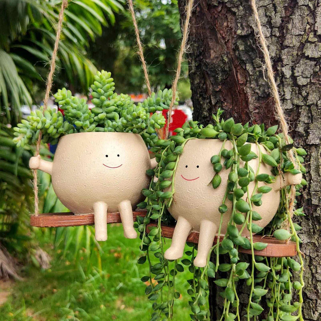 A charming face-shaped hanging planter with a swing design, perfect for adding personality and greenery to any indoor or outdoor space.